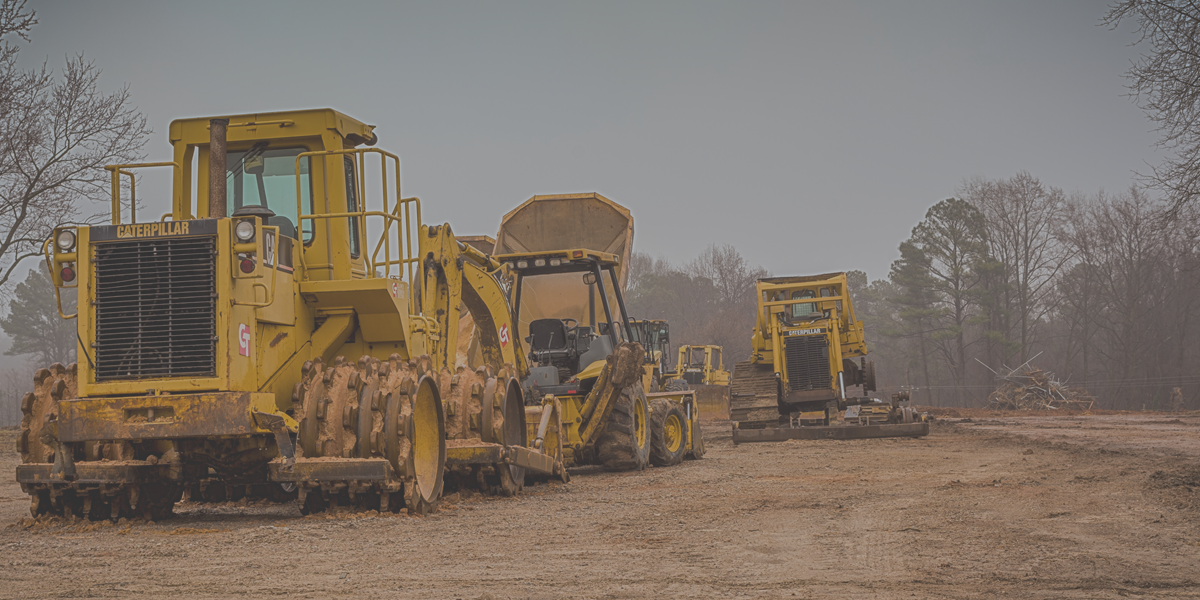Heavy-duty construction equipment, including excavators and loaders, at a work site